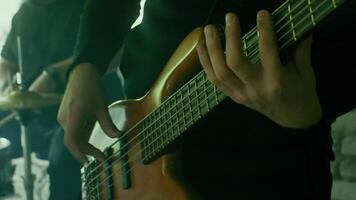 Close up of hands skillfully playing a bass guitar during rehearsal, generating captivating music filled with passion and precision, embodying the essence of live performance video