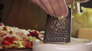 Clove of garlic was grated and added to delicious Caesar salad dressing in restaurant's kitchen. process of creating homemade sauce using natural ingredients. video