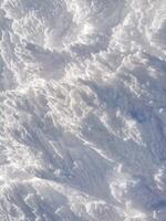 Vertical winter background with snow-covered mountain surface showcasing intricate patterns and textures photo