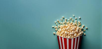 popcorn splashes from popcorn bucket on smooth background with copy empty space cinema photo