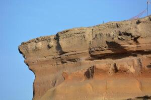 a large rock formation with a flag on top photo