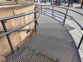 a metal railing on a sidewalk near a building photo