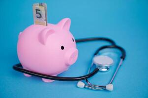 Managing health costs with a piggy bank and a stethoscope photo