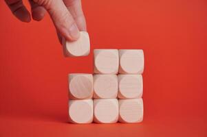 Building structure with wooden blocks on vibrant red background photo