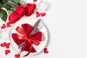 Valentines day romantic dinner concept. Beautiful table setting. Roses and candles on a white background. photo
