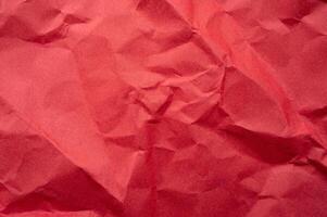 Full frame shot of crumpled red paper sheet texture and background. photo