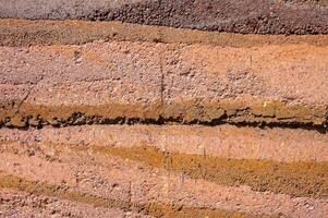 Full frame shot of an earthen wall texture of clay house structure. These walls are constructed by ramming a mixture of aggregates, including gravel, sand, silt and a small amount of clay. photo