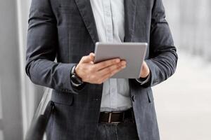 Happy Arab Businessman Booking Hotel Online While Using Digital Tablet In Airport, Handsome Middle Eastern Entrepreneur With Tab Computer Standing In Terminal, Waiting For Flight Boarding, Copy Space photo