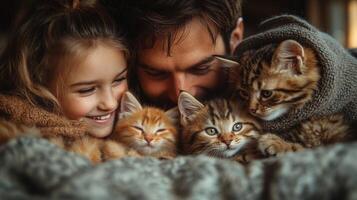 A man and a young girl share joyful laughter as they cuddle with four adorable kittens in a cozy indoor setting. They are wrapped in warm blankets, creating a heartwarming scene. photo