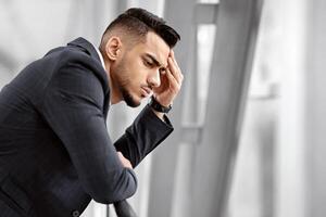 Portrait Of Pensive Middle Eastern Man In Suit Standing Near Window At Airport Terminal, Thoughtful Arab Businessman Waiting For Flight In Lounge, Having Business Problems Or Suffering From Headache photo