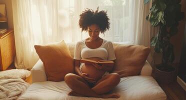 A woman sits comfortably on a couch at home, reading a book while cradling her pregnancy. Soft light filters through the window, creating a cozy atmosphere for relaxation. photo