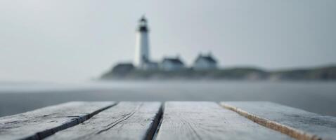 close up of empty wooden table with blurred lighthouse on shore background photo