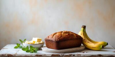 Golden loaf of banana bread surrounded by ingredients on a rustic table setting photo