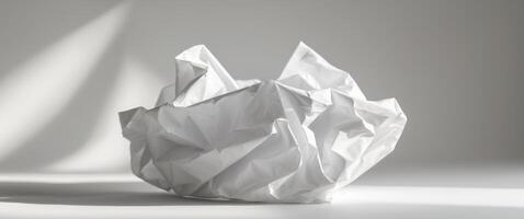 Crumpled white paper creates abstract shapes with light and shadow. photo