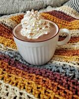 Cozy autumn evening with a warm mug of hot chocolate topped with whipped cream photo