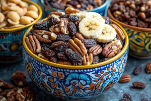 Pecans, raisins, and banana chips creating a healthy trail mix in colorful bowl photo