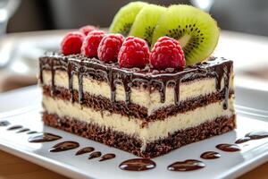 Delicious chocolate cake with kiwi and raspberries drizzled with chocolate sauce photo