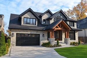 Modern stone luxury home with garage and landscaping on a sunny day photo