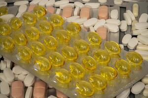Various types of pills and capsules displayed on a surface photo
