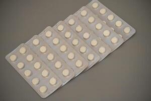 Tablets arranged in multiple strips on a neutral background photo