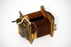 Old electrical transformer with copper windings and rusty casing photo