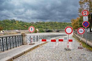 Road signs indicating that entry to the embankment is prohibited. Flood in Prague. View of Bridge over the flooding river Vltava, Prague. High quality photo