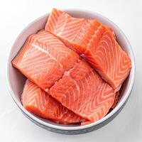 Top View of Fresh Salmon Fillets in a Bowl on a White Background photo