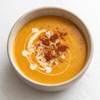 Top View of Creamy Pumpkin Soup with Cream and Spices on a White Background photo