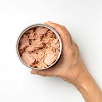 Top View of Hands holding a Canned Tuna in Oil on a White Background photo