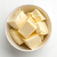 Top View of Butter Cubes in a Bowl on a White Background photo