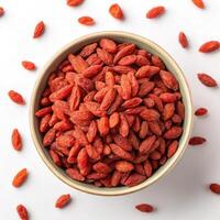 Top View of Dried Goji Berries in a Bowl on a White Background photo