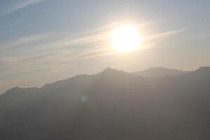 A person is standing on top of a mountain photo