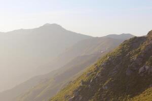 A person is standing on a mountain top photo
