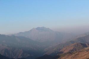 A person standing on a mountain top photo