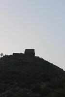A building on top of a hill with a blue sky photo