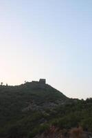 A hill with a small building on top of it photo
