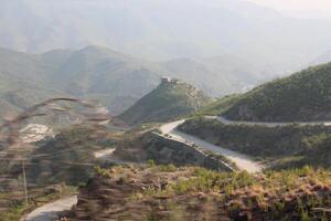 A winding road with a mountain in the background photo