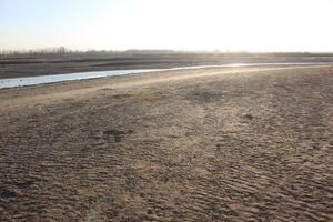 A man is walking on a sandy beach photo