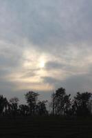 A cloudy sky with a sun shining through it photo