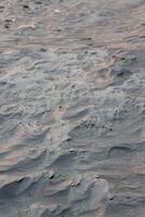 A sand dune with a wave pattern photo