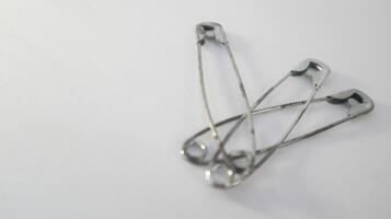 a photo of several safety pins on a white background