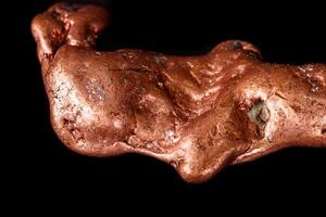 Macro mineral stone of a copper nugget on a microcline on a black background close up photo