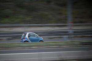 blue passenger car on the highway in motion with a blurred background photo