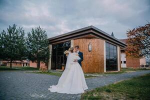 A bride and groom are standing in front of a building. photo