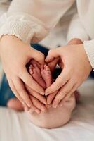 A close up of parents hands forming a heart around their newborns tiny feet, symbolizing love, family, and new beginnings. photo