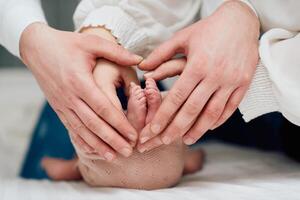 A close up of parents hands forming a heart around their newborns tiny feet, symbolizing love, family, and new beginnings. photo