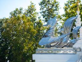 Silver swan statue at the entrance to the Thai temple. Thai art in the temple. Calm and believe. photo