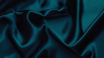 Dark teal satin with glossy waves and soft folds, enhancing the richness and sophistication of textile designs, luxury branding, and artistic decor. photo