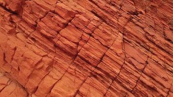 Warm, layered sandstone with detailed cracks and deep orange hues, representing natural geological formations ideal for backgrounds, architectural design, and abstract pattern inspirations. photo