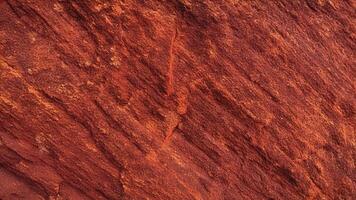 Warm-toned red sandstone with deep fissures and textured layers, reflecting natural geological patterns perfect for design, backgrounds, architectural projects, and artistic inspiration. photo